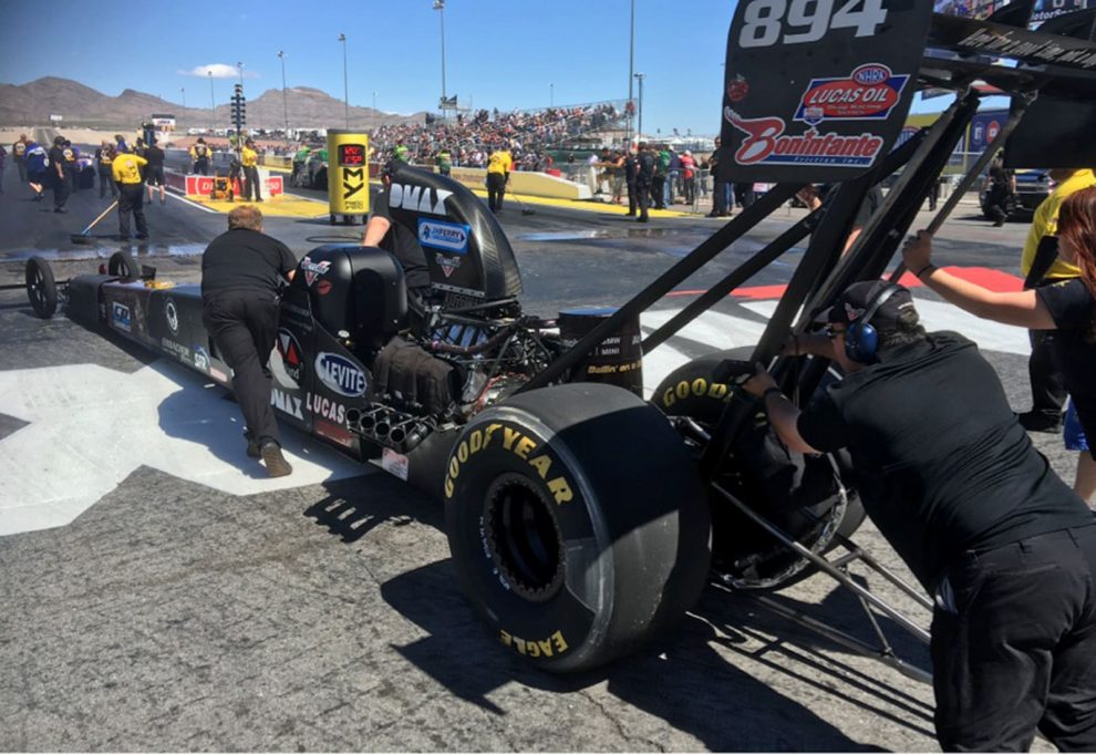 Tension avant la prochaine course : les assistants poussent le dragster A-Fuel pour Jndia au départ à Las Vegas.